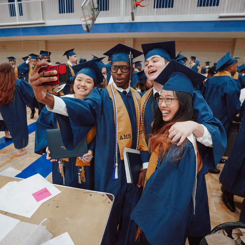 picture of students graduating from high school, students are taking a selfie with a smartphone